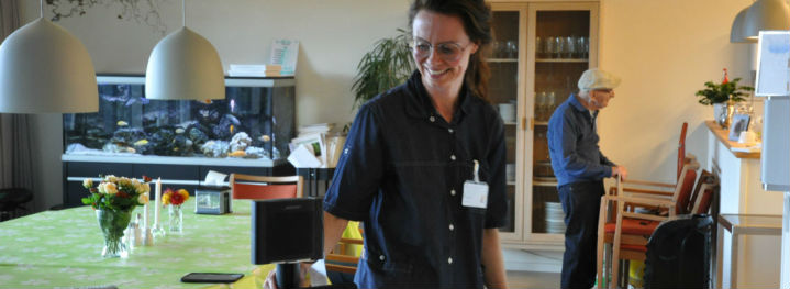 Sosu-assistent Lisbeth Møller triller rundt med iPad og højtaler på et stativ og er - efter lidt tilvænning - glad for at synge på sin arbejdsplads.<br />Foto: Emma Oxenbøll